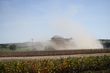 Formação de poeira gerada pela colheitadeira de soja no campo da plantação de soja.