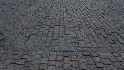 Fototapeta premium Close up cobblestone pavement, Granite cobblestoned pavement background. Stone pavement texture. Abstract background of cobblestone pavement close up. Seamless texture
