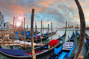 The spectacular sky reflects the beauty of Venice with the gondolas in the foreground, an...