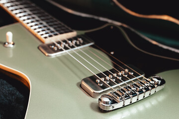 Fototapeta na wymiar Close-up of a high gloss metallic sage green guitar