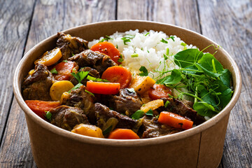 Takeaway food - roast pork with carrots and celeriac in sauce with white rice in lunch box on...