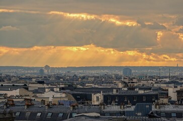 Vue panoramique sur le ciel de Paris en hauteur et rayons du soleil traversant les nuages, avec...
