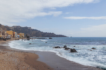 Ionian Sea shore in Giardini Naxos in the Metropolitan City of Messina on the island of Sicily,...