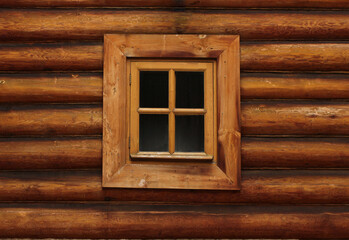 textured wall of a vintage log house with a window