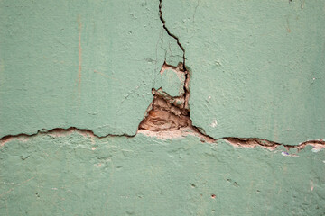 brick wall with green paint and peeling plaster