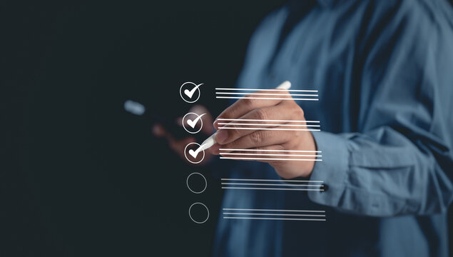Digital Assessment Concept : Businessman Uses Mobile for Evaluation, Survey Exam, Survey Completion, and Checklist or Fills Assessment Survey for Performance Checklist.	
