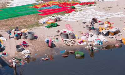 Indian people washing cloth on the sandy banks of Yamuna river in Agra