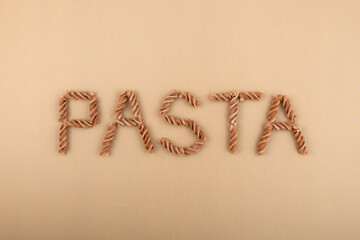 The word PASTA is lined with gluten-free Pasta di Lino. Fusilli made from flax and corn flour. Low glycemic index food concept