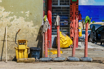 Fototapeta na wymiar Four old plastic traffic post with wet rags over them and a couple of buckets at the side, in a gas station in the town of Arcabuco in central Colombia.