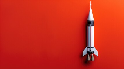 White rocket model centered on a vibrant red backdrop - obrazy, fototapety, plakaty