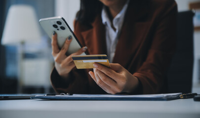 Hands holding plastic credit card and using laptop. Online shopping concept. Toned picture