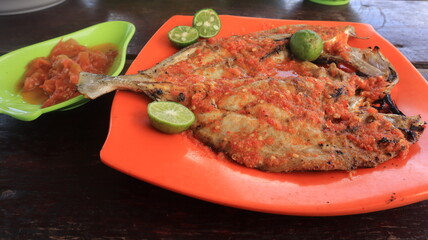 Delicious grilled fish sprinkled with chili is served on the table