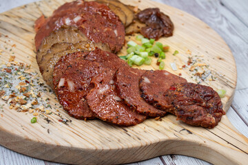 Seitan vegan Ham  and Peperoni, plant based. Sliced, on wooden board