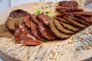 Seitan vegan Ham  and Peperoni, plant based. Sliced, on wooden board