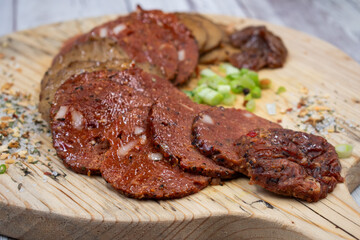 Seitan vegan Ham  and Peperoni, plant based. Sliced, on wooden board