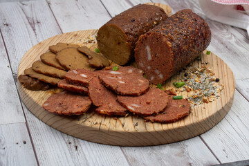 Seitan vegan Ham  and Peperoni, plant based. Sliced, on wooden board