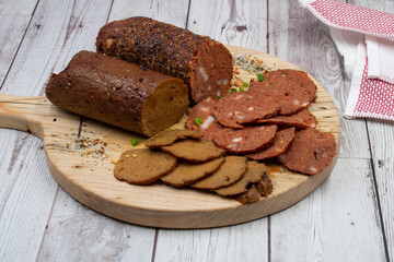 Seitan vegan Ham  and Peperoni, plant based. Sliced, on wooden board
