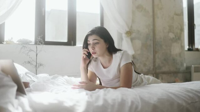Irritated arguing young woman yelling at mobile phone while laying on bed at home Angry nervous female talk on smartphone expressing negative emotion Bad conflict working or personal conversation