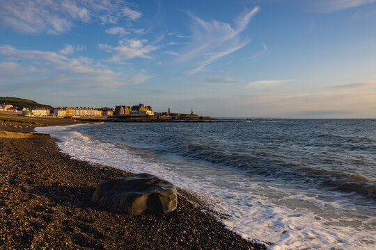 Evening tide on the beach in Aberystwyth at sunset.