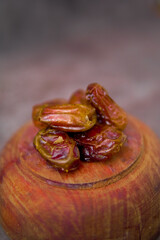 Front view of dried dates or kurma on wooden plate isolated 