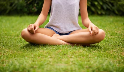 Tischdecke Meditation, yoga and zen with woman on grass, lawn or garden outdoor for wellness, peace or to relax in nature. Female person, lady and gen z girl in lotus position by park, plants or landscape © Arcurs Corp/peopleimages.com