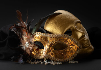 Golden Venetian carnival masks on a black background.