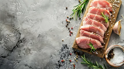 Fotobehang Raw pork meat on wooden board on grey background with rosemary, salt and pepper. Pork loin. Copy space © buraratn