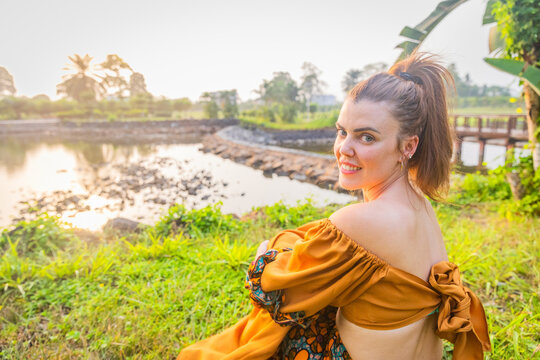 Portrait of a Caucasian girl wearing African clothing sitting in a park in Malabo