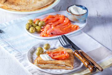 Pancakes with gravlax, cottage cheese and olives. A traditional dish for Maslenitsa or Carnival. - 754313219