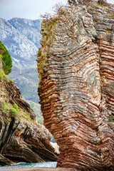 Sheer cliff in the sea against the backdrop of mountains
