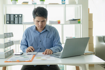 Fototapeta na wymiar Professional Asian male salesman is presenting paper documents to customers with laptop from his home office, remote communication with online meeting.