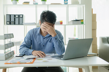 Business concept of a businessman with a headache while working sitting stressed at a desk with a...