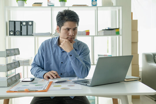 Professional Asian male salesman is presenting paper documents to customers with laptop from his home office, remote communication with online meeting.