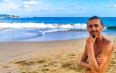 Fototapeta na wymiar Handsome male tourist traveler at tropical beach in Mazunte Mexico.