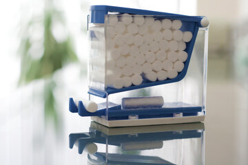Blue Container Filled with White Cotton Balls on a Glassy Surface