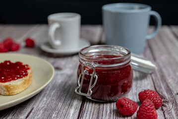 Homemade raspberry jam in glass jar, healthy breakfast with toast and raspberry jam