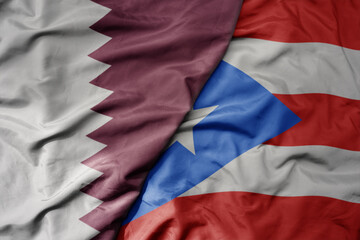 big waving national colorful flag of puerto rico and national flag of qatar.