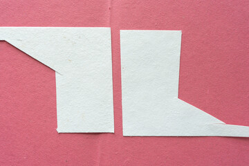 two pieces of cut white paper card on rough pink paper