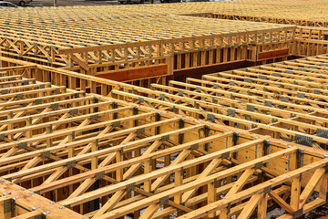 Floor joists at top of first floor ready for second floor construction to begin on multi story wood...