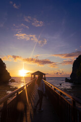 Silhouette of a woman at sunset on a gazebo by the beach. Portrait. Bil-At Point, Ferrol, Romblon,...