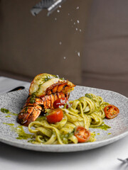 Pasta with langoustines, Parmesan, cherry tomatoes, and pesto sauce