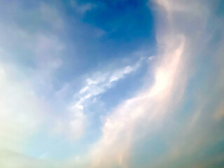 Fototapeta na wymiar heavenly blue sky with wispy cirrus clouds and sunlight; background