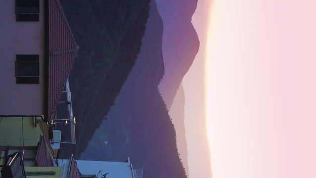 The setting sun illuminates the roofs of a medieval town in the mountains. Perinaldo, Italy.