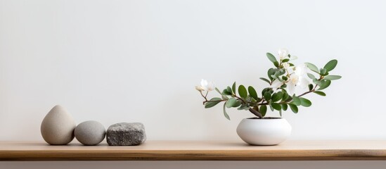 A vintage wooden table shelf displays a vase filled with white flowers, surrounded by rocks. The setting exudes a minimalist and zen vibe within a modern interior design.