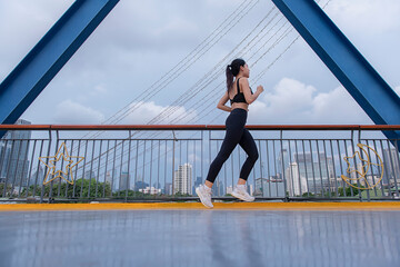 slow speed shutter woman running  on the bridge in the city.  blur woman runner on bridge. young fitness woman runner, Healthy lifestyle concept