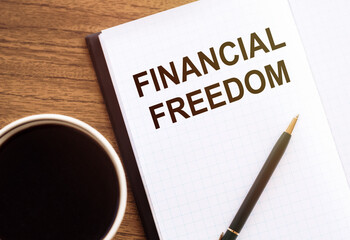 Business concept - Top view notebook writing Financial Freedom