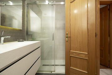 Small bathroom with white porcelain toilets with drawers and shower cabin with tempered glass...