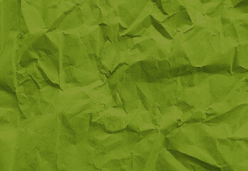 close up texture of green crumpled or torn old craft paper use as background with blank space for design. creased recycle green craft paper texture.