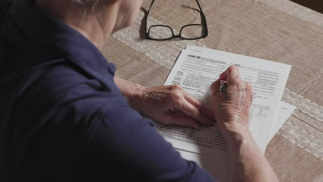 senior woman working on taxes with a 1040-SR