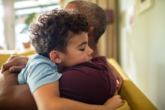 Father hugging son on the couch at home